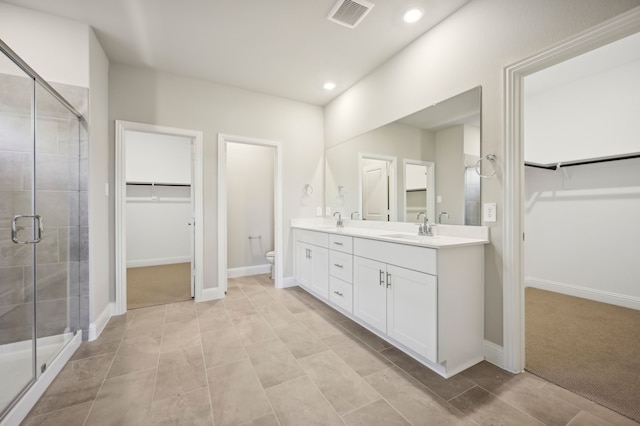 604 Willet Dr, Mckinney, TX 75069 - full bathroom featuring a shower stall, toilet, recessed lighting, double vanity, and a walk in closet