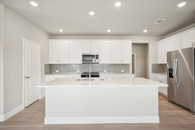 604 Willet Dr, Mckinney, TX 75069 - kitchen with appliances with stainless steel finishes, a kitchen island with sink, decorative backsplash, light countertops, and recessed lighting
