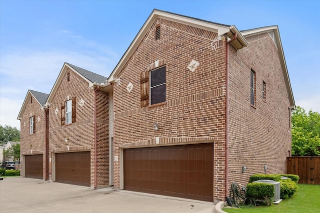 13336 Patito Pl Unit 7, Dallas, TX 75240 - view of property exterior featuring driveway, cooling unit, brick siding, and an attached garage
