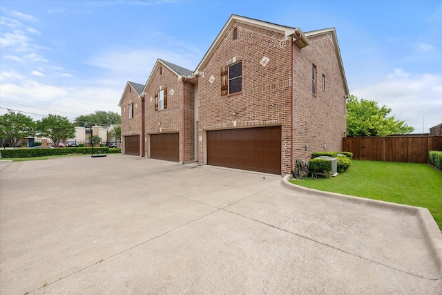 13336 Patito Pl Unit 7, Dallas, TX 75240 - view of side of home featuring a lawn, driveway, brick siding, fence, and a garage