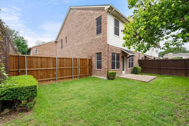 13336 Patito Pl Unit 7, Dallas, TX 75240 - back of property featuring a lawn, a patio area, brick siding, and a fenced backyard