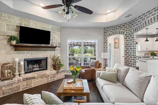 6093 S Fm 730, Decatur, TX 76234 - living area featuring ceiling fan, wood finished floors, a fireplace, and a raised ceiling
