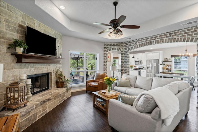 6093 S Fm 730, Decatur, TX 76234 - living room with a ceiling fan, arched walkways, a fireplace, a chandelier, and dark wood finished floors