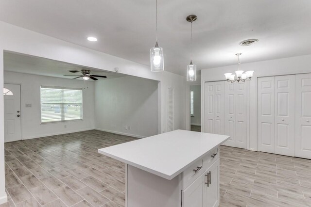 kitchen with ceiling fan with notable chandelier, white cabinetry, visible vents, decorative light fixtures, and light countertops