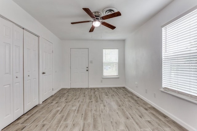 entrance foyer featuring baseboards, light wood finished floors, ceiling fan, and visible vents