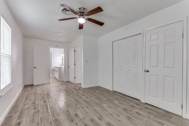 unfurnished bedroom featuring light wood finished floors, a closet, baseboards, and a ceiling fan
