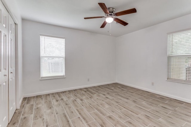 unfurnished bedroom featuring a ceiling fan, a closet, light wood-type flooring, and baseboards