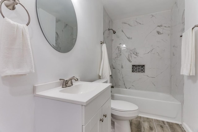 bathroom with toilet,  shower combination, vanity, and wood finished floors
