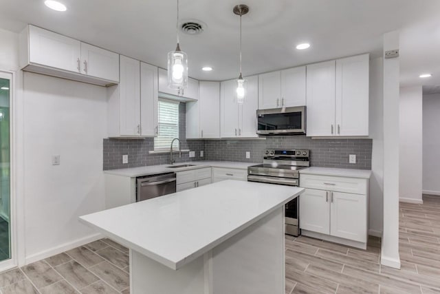 kitchen featuring stainless steel appliances, baseboards, visible vents, a sink, and light countertops