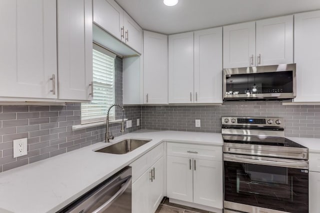 kitchen featuring light countertops, white cabinets, appliances with stainless steel finishes, and a sink