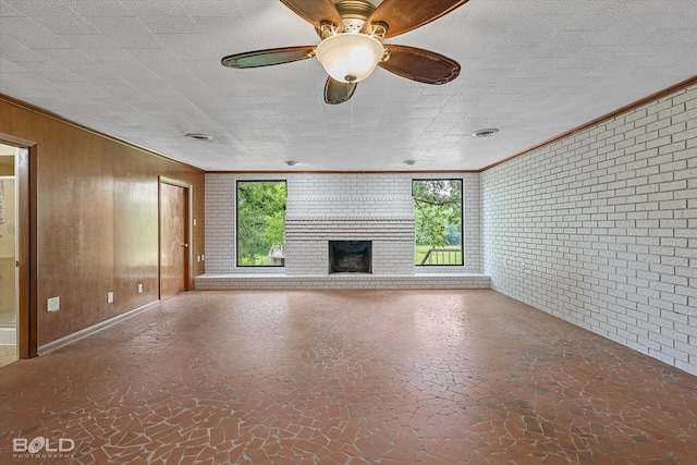 5764 Jefferson Paige Rd, Shreveport, LA 71119 - unfurnished living room with brick wall, plenty of natural light, crown molding, a fireplace, and wooden walls