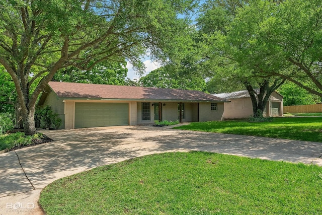 ranch-style home featuring concrete driveway, an attached garage, a front lawn, and concrete block siding