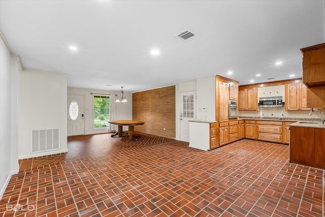 kitchen featuring a sink, brick patterned floor, visible vents, and appliances with stainless steel finishes
