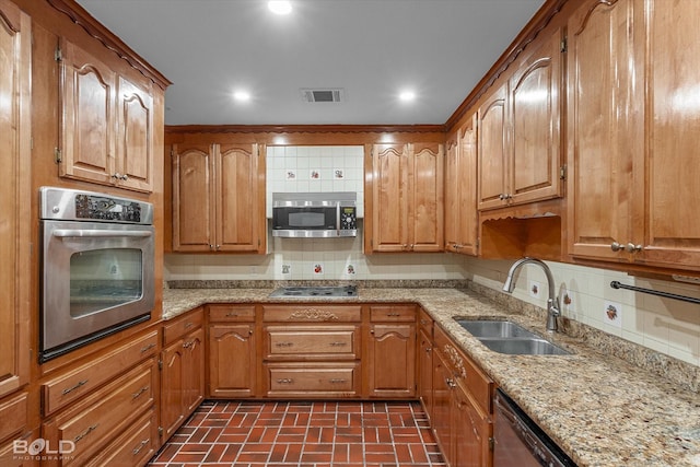 kitchen featuring a sink, visible vents, backsplash, brick patterned floor, and appliances with stainless steel finishes