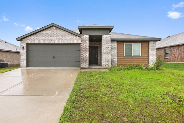 view of front of house featuring a front lawn, driveway, brick siding, and a garage