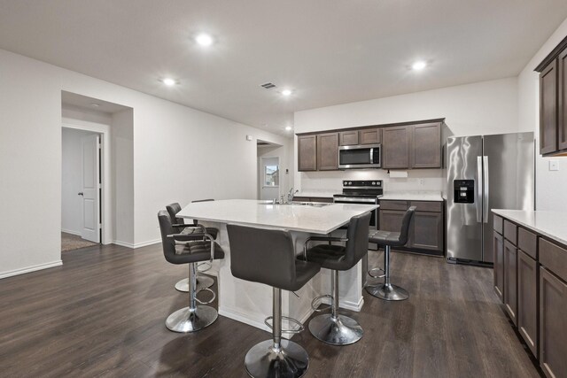 kitchen featuring light countertops, stainless steel appliances, dark wood-style flooring, and a sink