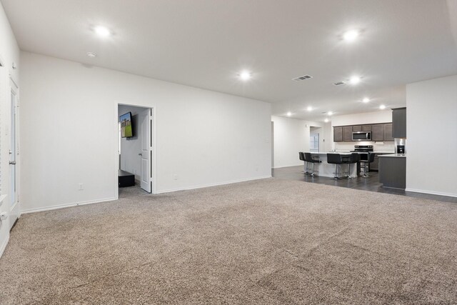 unfurnished living room with baseboards, visible vents, and recessed lighting