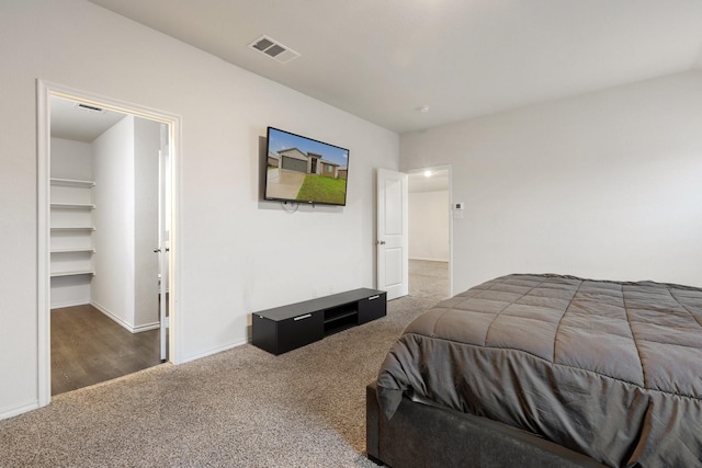 carpeted bedroom featuring a spacious closet, baseboards, and visible vents