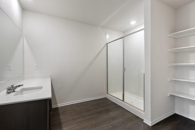full bathroom featuring a shower stall, baseboards, vanity, and wood finished floors