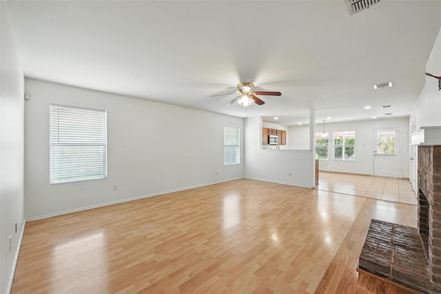 3105 Lipizzan Dr, Denton, TX 76210 - unfurnished living room with a ceiling fan, light wood finished floors, a fireplace, recessed lighting, and baseboards