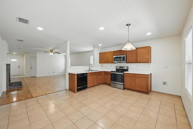 3105 Lipizzan Dr, Denton, TX 76210 - kitchen featuring stainless steel appliances, light countertops, a sink, ceiling fan, and brown cabinets