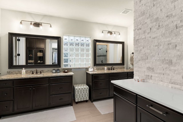 bathroom with two vanities, visible vents, and a sink