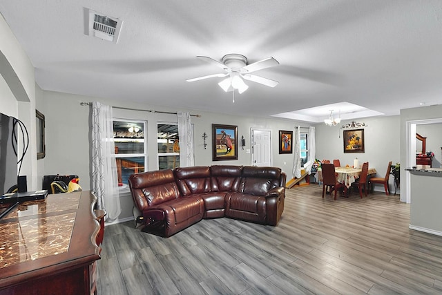 600 Saint Luke St, Terrell, TX 75160 - living area with baseboards, visible vents, wood finished floors, and ceiling fan with notable chandelier