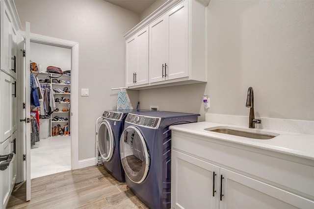 1008 Trinity Oaks Rd, Weatherford, TX 76087 - laundry area featuring cabinet space, independent washer and dryer, and light wood-type flooring