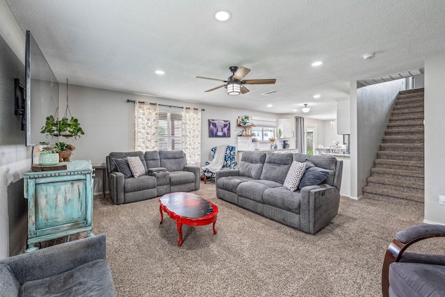 carpeted living area featuring stairs, recessed lighting, ceiling fan, and a textured ceiling