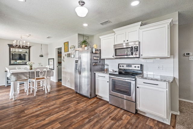 kitchen featuring stainless steel appliances, a textured ceiling, visible vents, dark wood-style flooring, and white cabinets