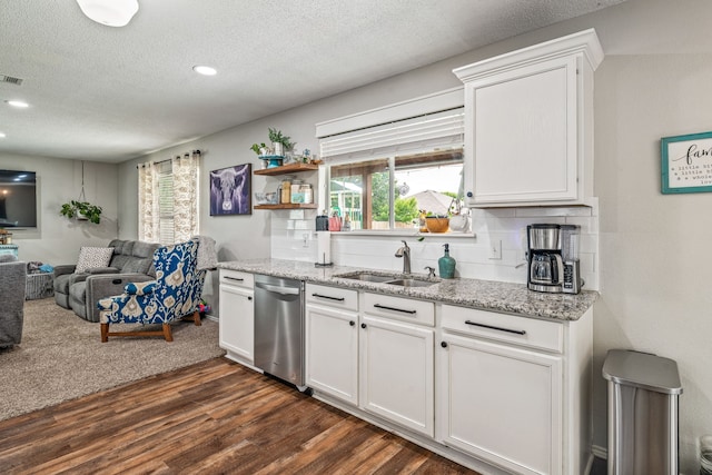 kitchen featuring a sink, a textured ceiling, open floor plan, dark wood-style floors, and stainless steel dishwasher