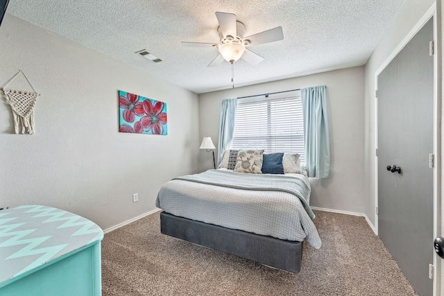 carpeted bedroom with baseboards, ceiling fan, visible vents, and a textured ceiling