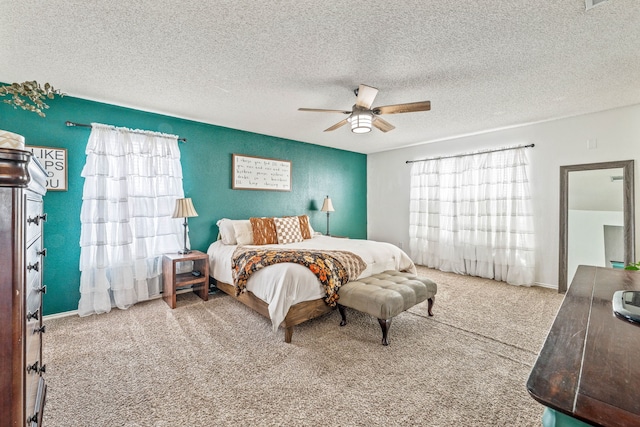 carpeted bedroom featuring a textured ceiling, baseboards, and ceiling fan