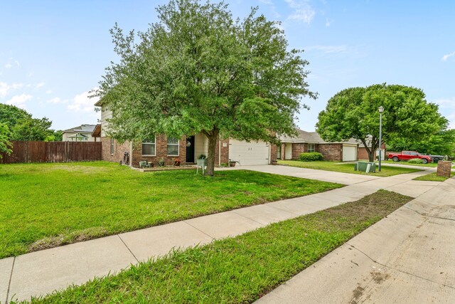 obstructed view of property featuring driveway, brick siding, fence, a garage, and a front yard