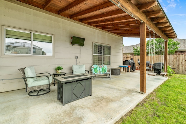 view of patio featuring fence, area for grilling, and a fire pit