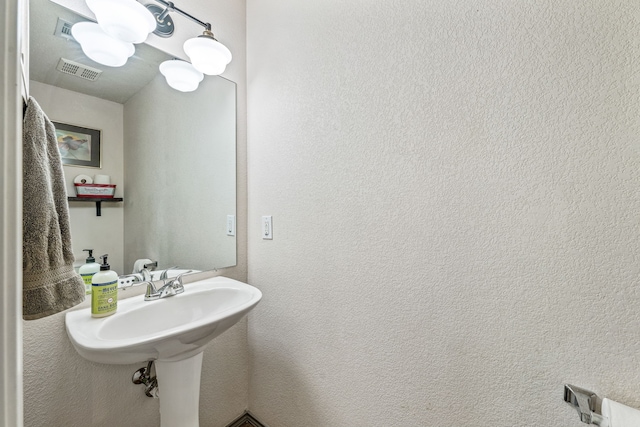 bathroom featuring visible vents and a textured wall