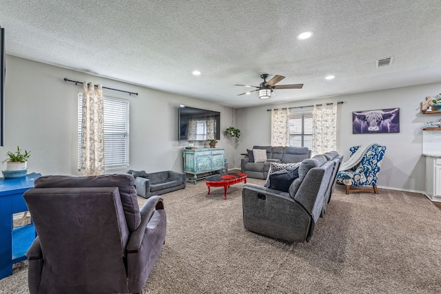 carpeted living area featuring a textured ceiling, visible vents, recessed lighting, ceiling fan, and baseboards
