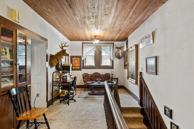 interior space with wooden ceiling, an inviting chandelier, carpet flooring, and baseboards