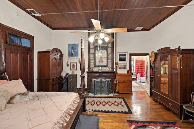 bedroom with wood ceiling, visible vents, and wood finished floors