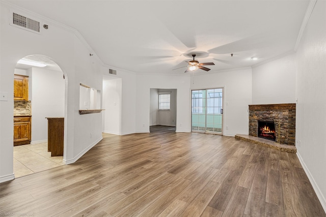 unfurnished living room featuring ornamental molding, light wood-type flooring, visible vents, and ceiling fan