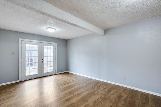 2105 Warnford Pl, Arlington, TX 76015 - spare room with a textured ceiling, baseboards, french doors, and wood finished floors