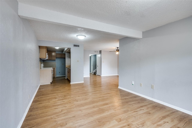 2105 Warnford Pl, Arlington, TX 76015 - unfurnished living room featuring a textured ceiling, light wood-type flooring, visible vents, a ceiling fan, and baseboards