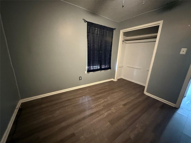 1141 Bowie St, Sulphur Springs, TX 75482 - unfurnished bedroom featuring dark wood finished floors, baseboards, a closet, and a textured ceiling