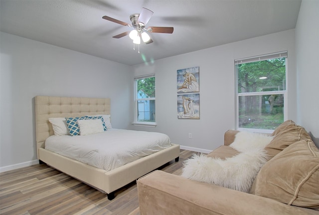 bedroom featuring wood finished floors, baseboards, and ceiling fan