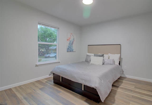 bedroom with baseboards and wood finished floors