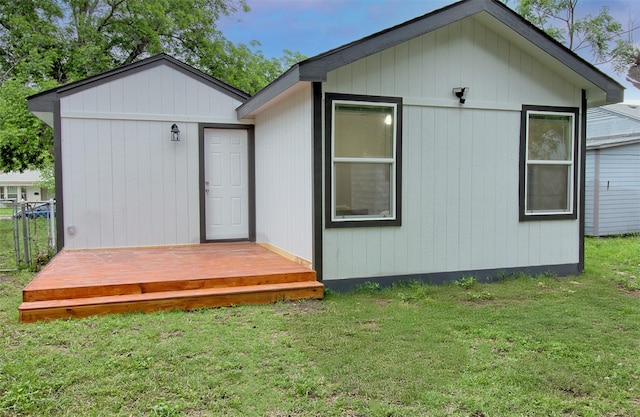 back of property with a yard and an outdoor structure
