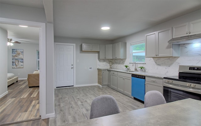 kitchen featuring a sink, stainless steel electric range, dishwashing machine, under cabinet range hood, and baseboards