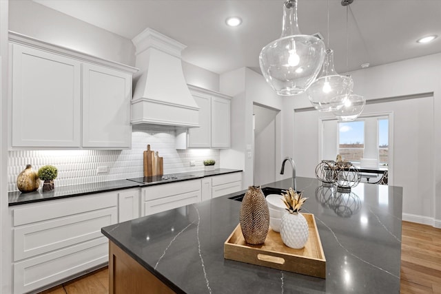 913 Beall St, Denton, TX 76207 - kitchen with custom exhaust hood, decorative backsplash, dark stone countertops, and white cabinets