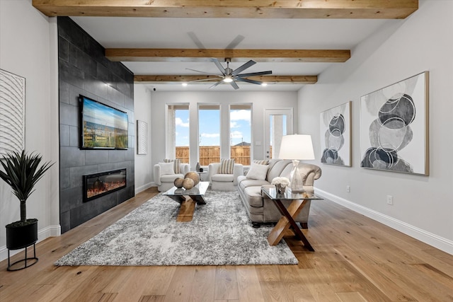 913 Beall St, Denton, TX 76207 - living area with baseboards, light wood finished floors, a tiled fireplace, and a ceiling fan
