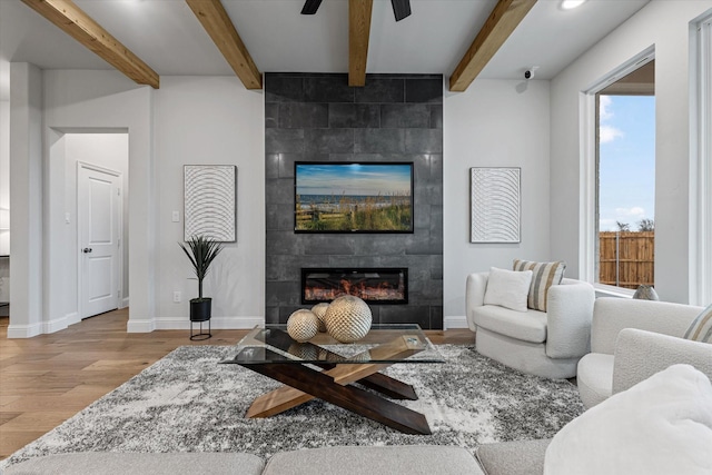 913 Beall St, Denton, TX 76207 - living room featuring a ceiling fan, baseboards, a tiled fireplace, and wood finished floors